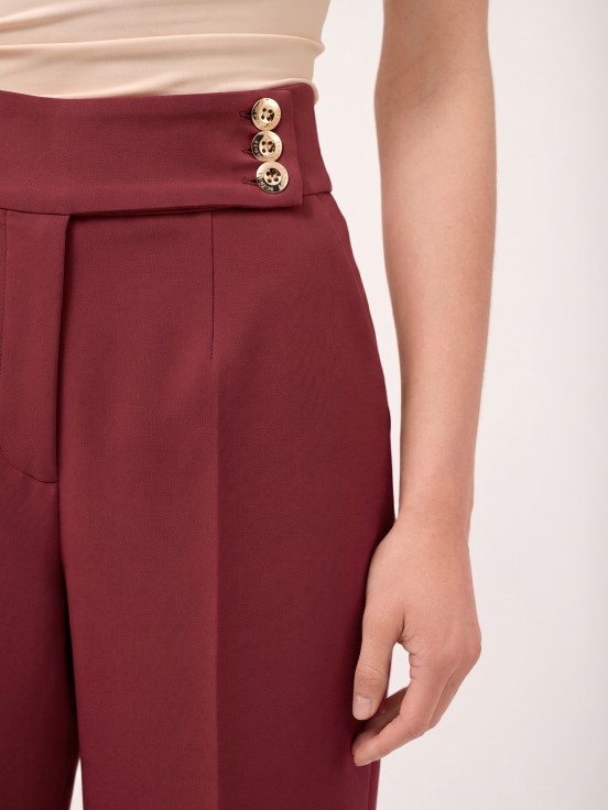 Trousers with buttoned strap